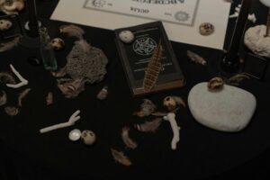 a witch's altar, with a spellbook, bones, and miscellaneous spooky props
