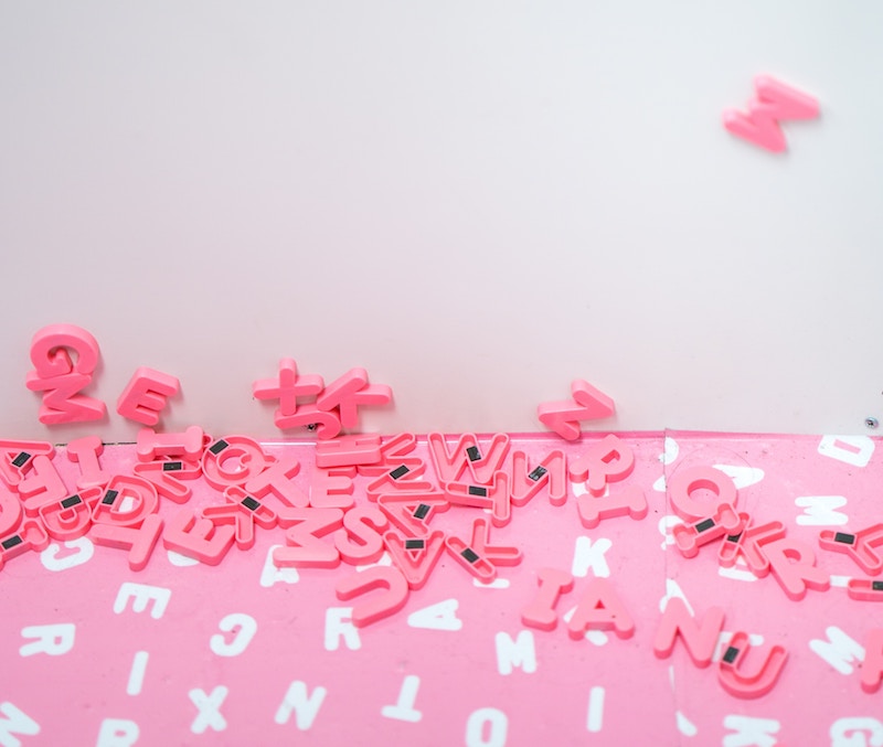 Pink magnet letters on a pink and white letter background. 