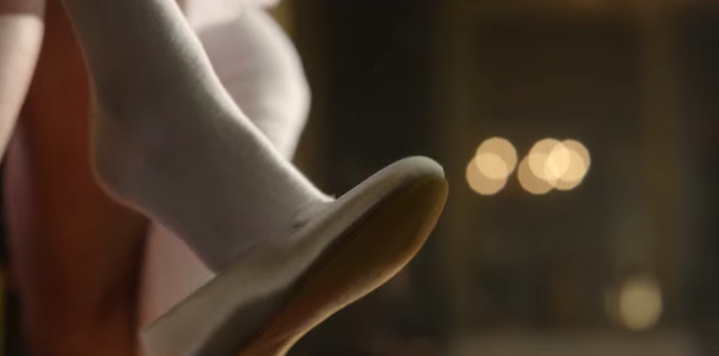 Daphne's shoe dangles from her foot.