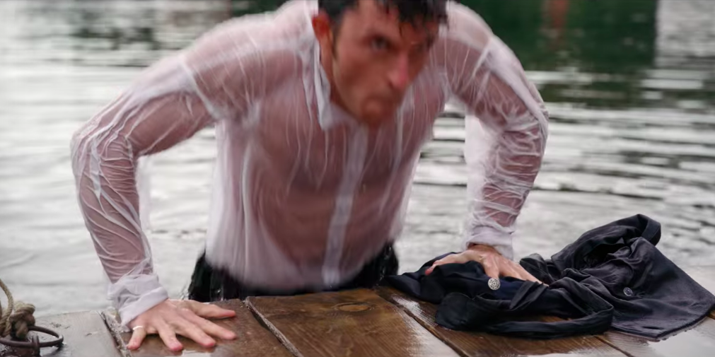 Anthony pulls himself out of the lake, soaked through to the skin.