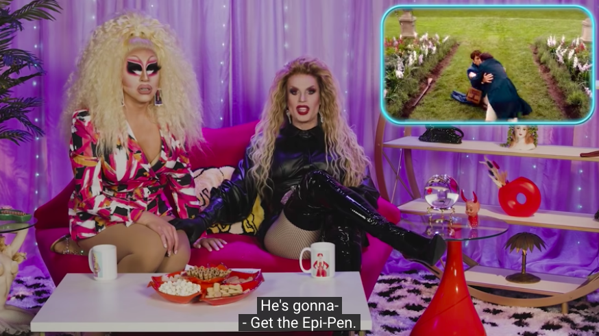 A shot of Trixie and Katya watching the part in Bridgerton where Anthony's dad is stung by the be. "Get the Epi-Pen."