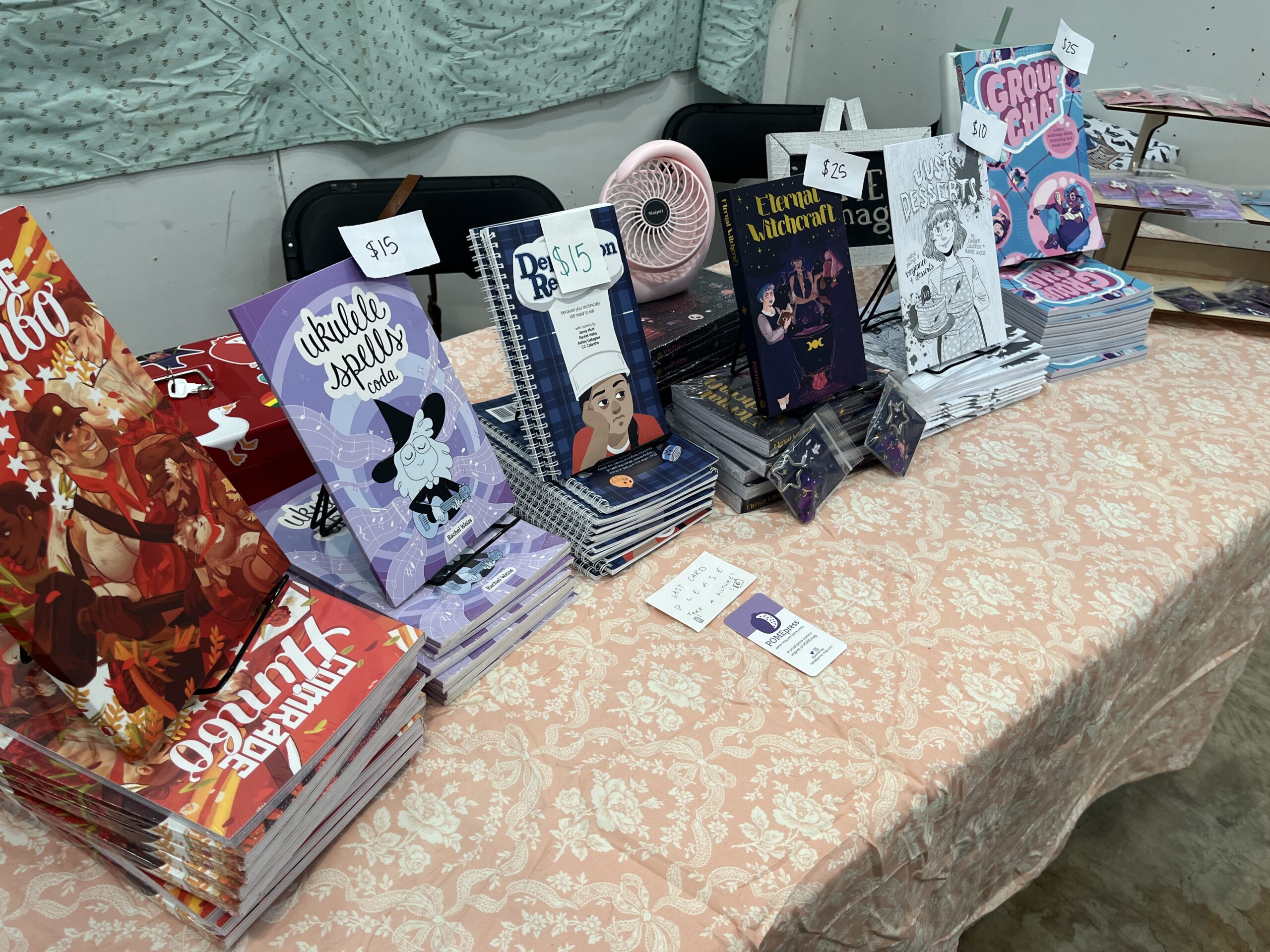 Spread of POMEpress books at the 2024 Lone Star Zine Fest